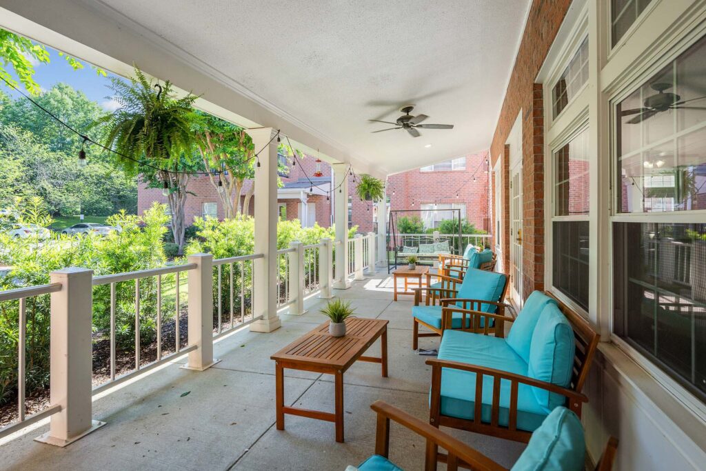 Spacious covered terrace overlooking gardens at Town Village Audubon Park, an ideal senior living community.