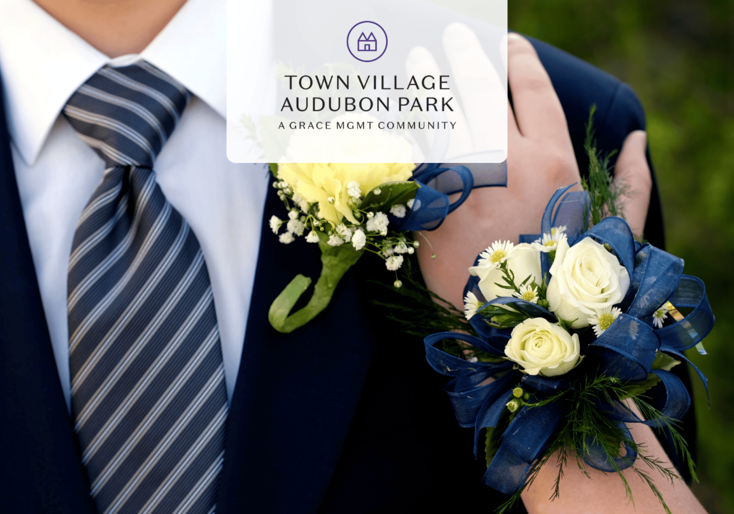 Groom in a navy suit with a striped tie, wearing a white rose boutonniere and a blue ribbon corsage; Town Village Audubon Park logo overlayed